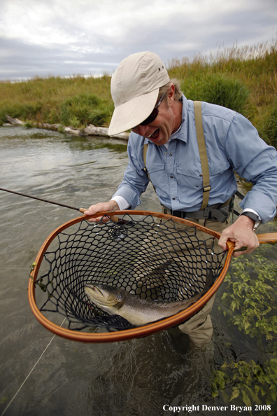 Flyfisherman with brown trout in net