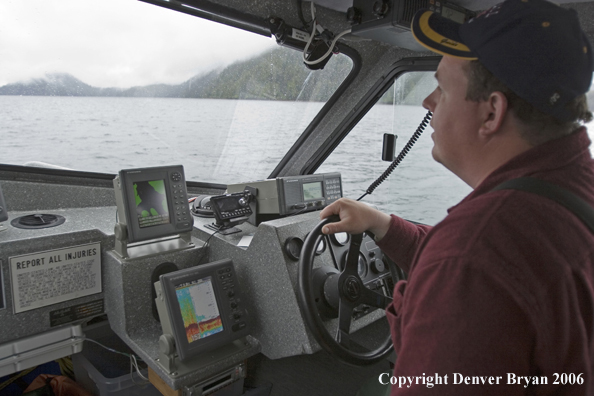 Boat captain at the helm looking for fish.  