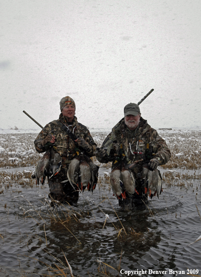 Waterfowl hunters with killed mallard ducks.