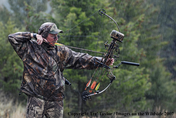 Bowhunter drawing back bow