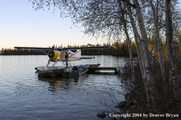 Float plane and fishing boats tied up to the dock at dusk.  Saskatchewan.