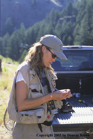 Woman Flyfisher rigging up to fish.