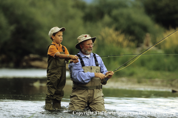 Grandfather teaching grandson how to fish