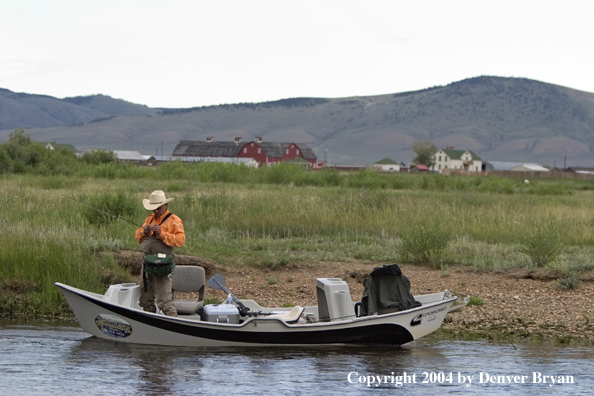 Flyfisherman in drift boat rigging up to fish.