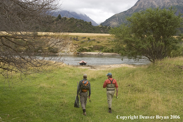 Flyfishermen walking to river.  Driftboat in background.