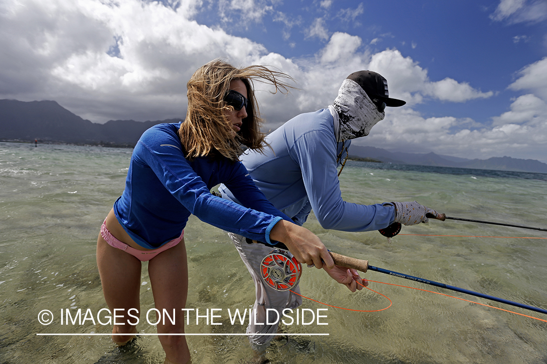 Woman flyfishing in saltwater with guide.