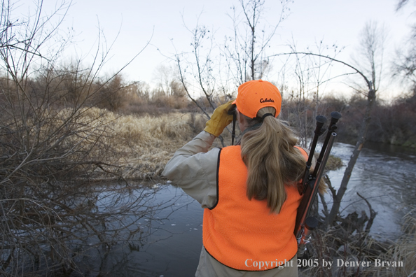 Woman big game hunter glassing for game.