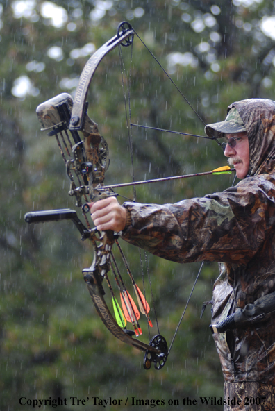 Bowhunter drawing back bow