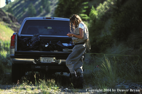 Woman flyfisher tying flies.