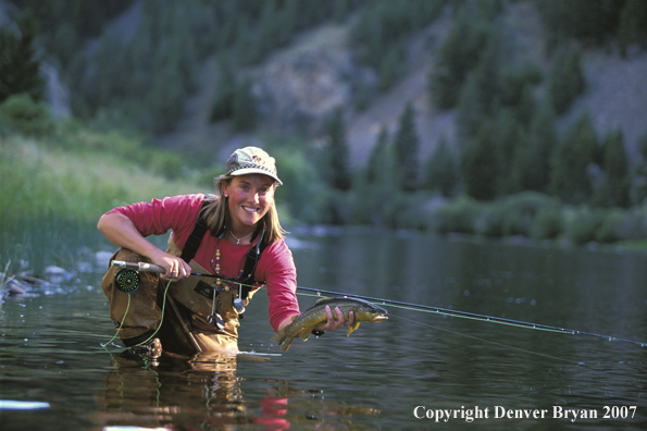 Flyfisher holding/releasing trout.