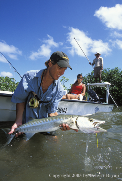 Saltwater flyfisherman with barricuda, woman on boat.