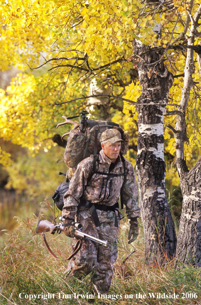 Muzzleloader hunter packing caped out mule deer.