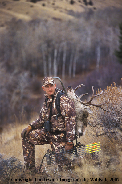 Bow hunter with caped mule deer on back.