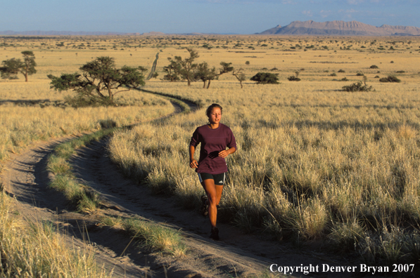 Woman running on road, Namibia. Africa.