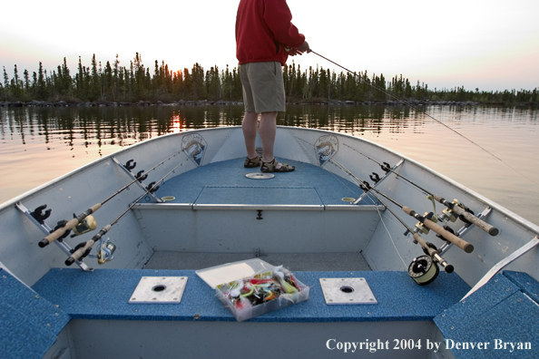 Flyfisherman fishing lake from bow of boat.