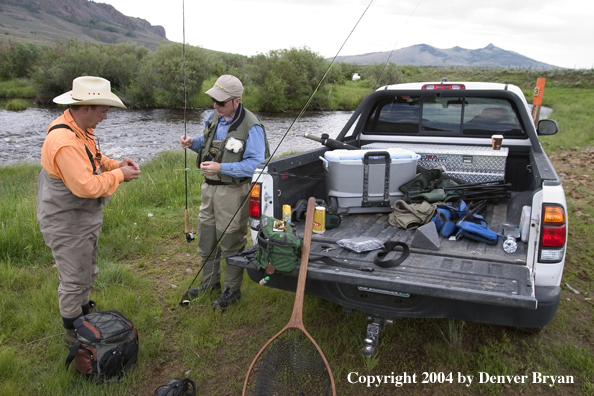 Flyfisherman next to truck, rigging up to fish (MR).