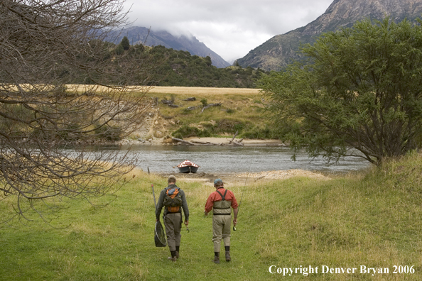 Flyfishermen walking to river.  Driftboat in background.