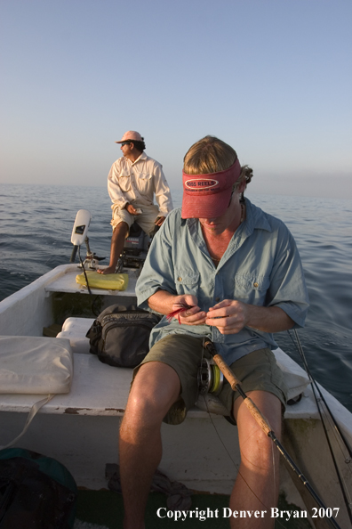 Saltwater flyfisherman tying fly on