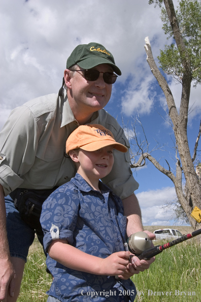 Father helping son spincast fishing.