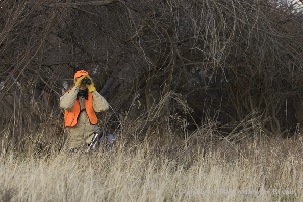 Woman big game hunter glassing for game.