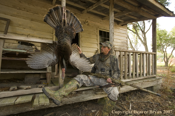 Turkey hunter in field with bagged bird