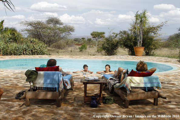 Family around pool on safari