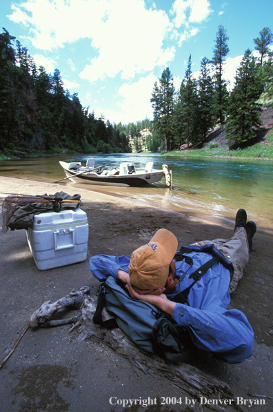 Flyfisherman taking a break on shore.