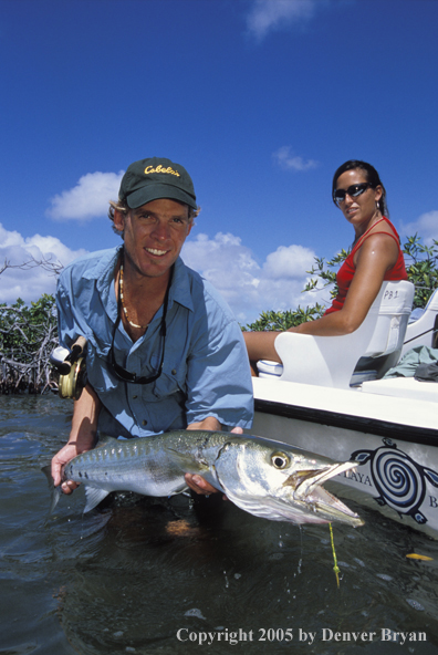 Saltwater flyfisherman with barricuda, woman on boat.