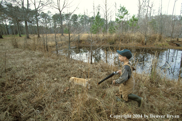 Young hunter with yellow Lab pup.