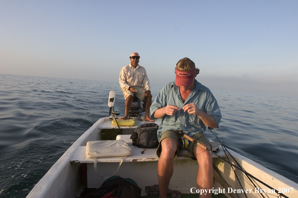 Saltwater flyfisherman tying fly on