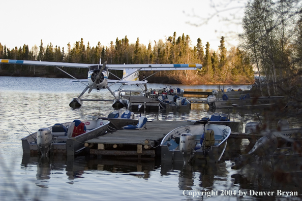 Float plane and fishing boats tied up to the dock at dusk.  Saskatchewan.