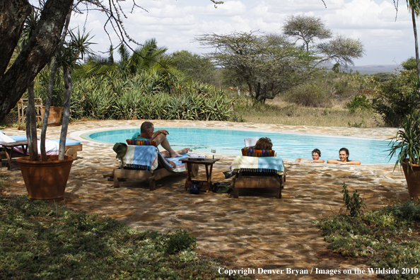 Family around pool on safari