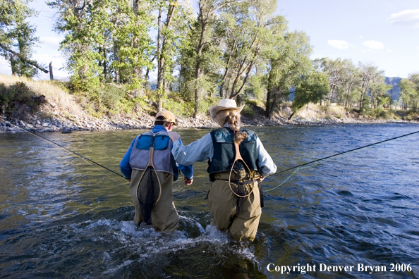 Flyfishermen walking across river.