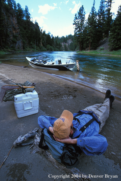 Flyfisherman taking a break on shore.