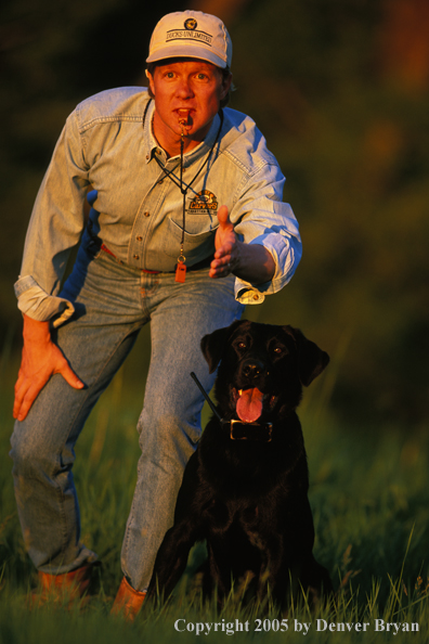 Trainer with black Labrador Retriever.