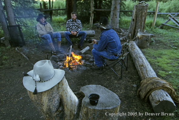 Cowboys sitting around campfire.