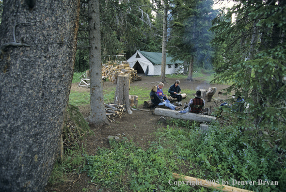 Cowboys and campers sitting around campfire.