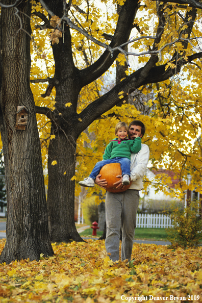 Father Carrying Child and Pumpkin