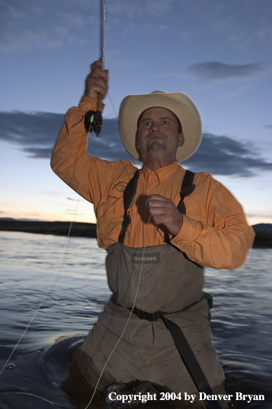 Flyfisherman playing fish at dusk (MR)