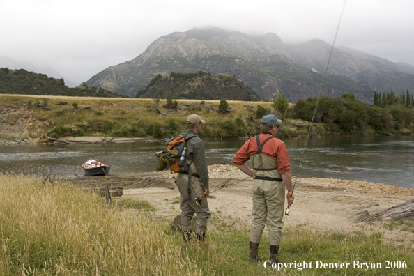 Flyfishermen checking out river.  Driftboat in background.