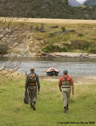 Flyfishermen walking to river.  Driftboat in background.