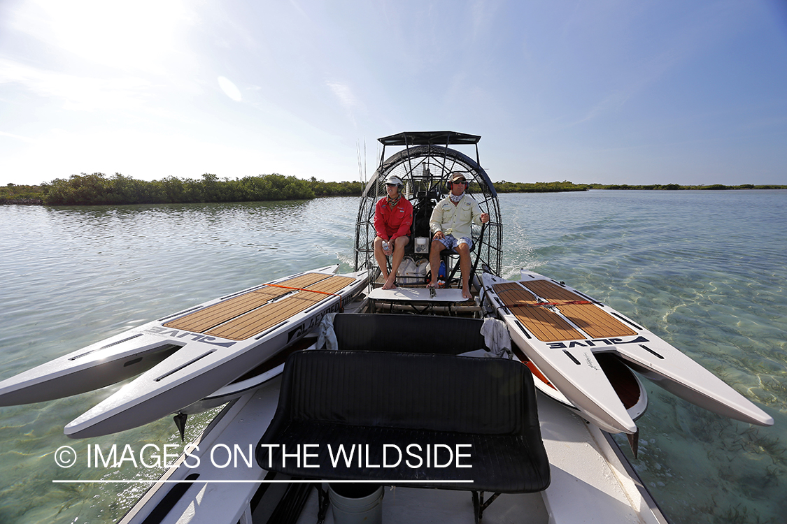 Flyfishermen on airboat with stand up paddle boards.