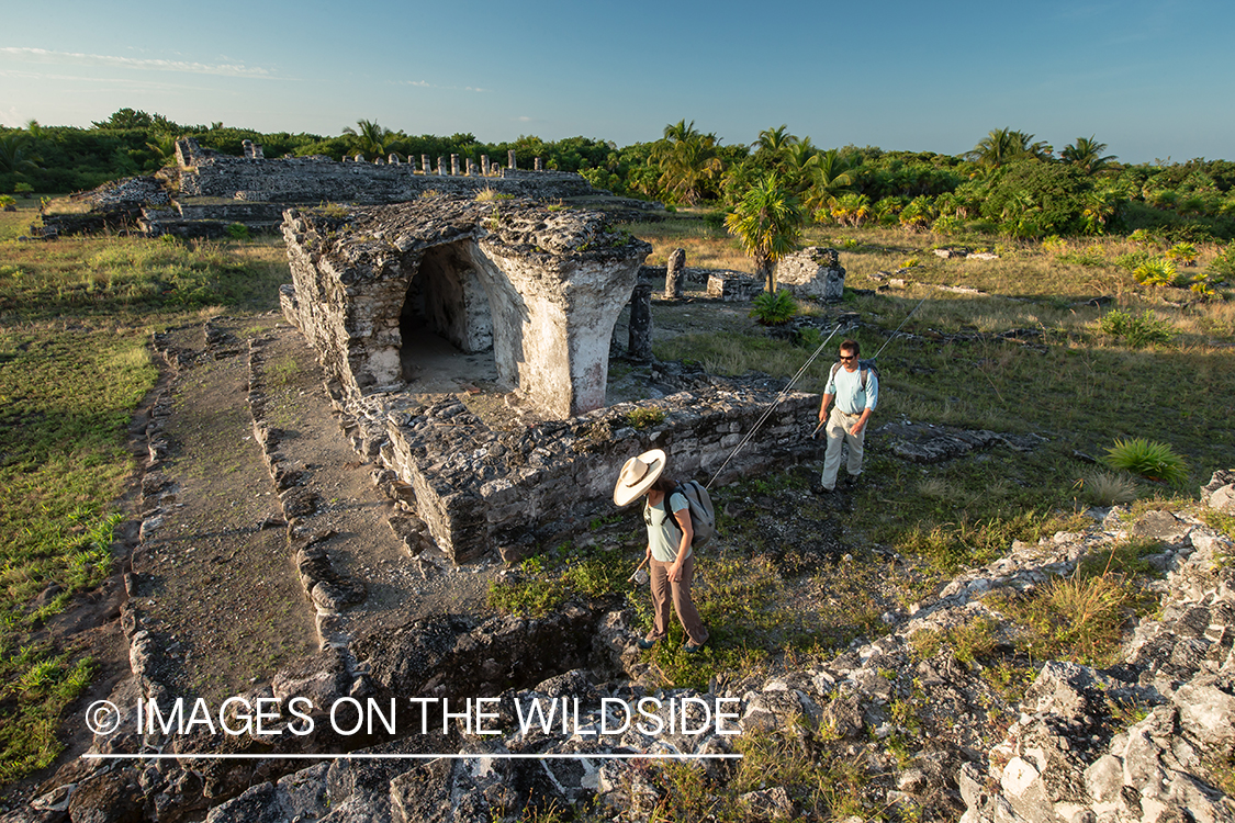 Flyfishermen walking through ruins to fishing location.