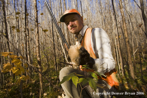 Upland bird hunter in field with bagged woodcock