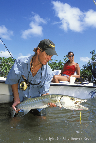 Saltwater flyfisherman with barricuda, woman on boat.