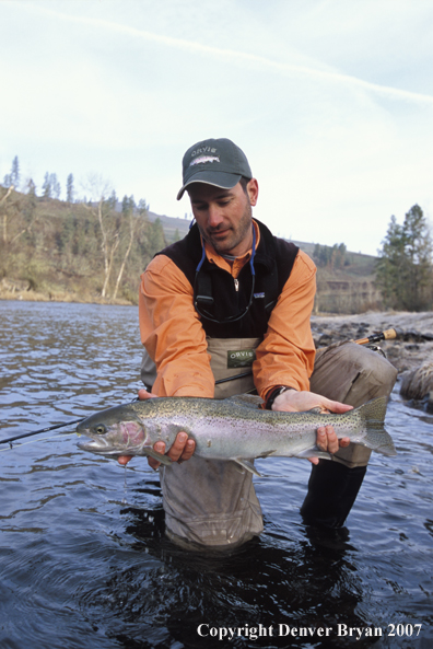 Flyfisherman releasing steelhead.