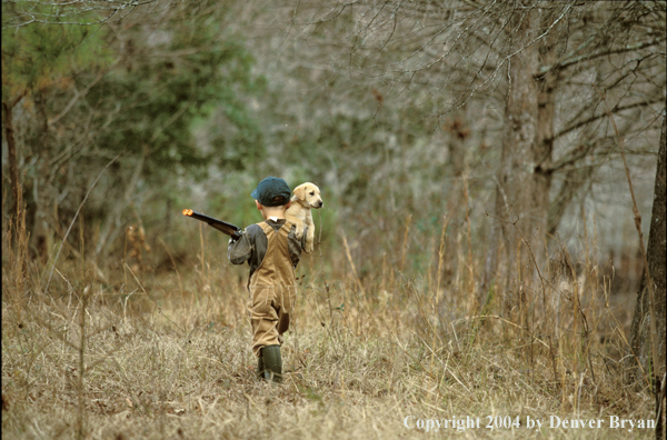 Young hunter with yellow Lab pup.