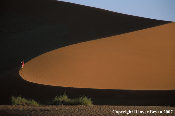 Woman running on sand dunes in Sossusvlei park, Namibia. Africa