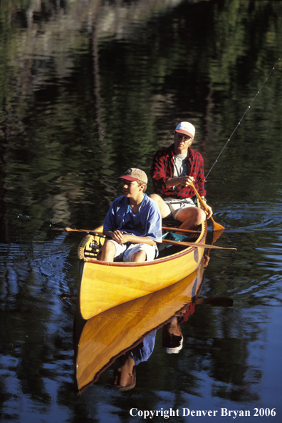 Father and son fishing from cedar canoe.