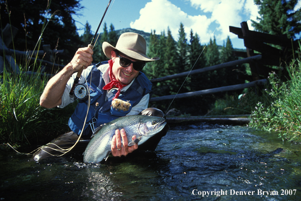 Flyfisherman holding rainbow trout.